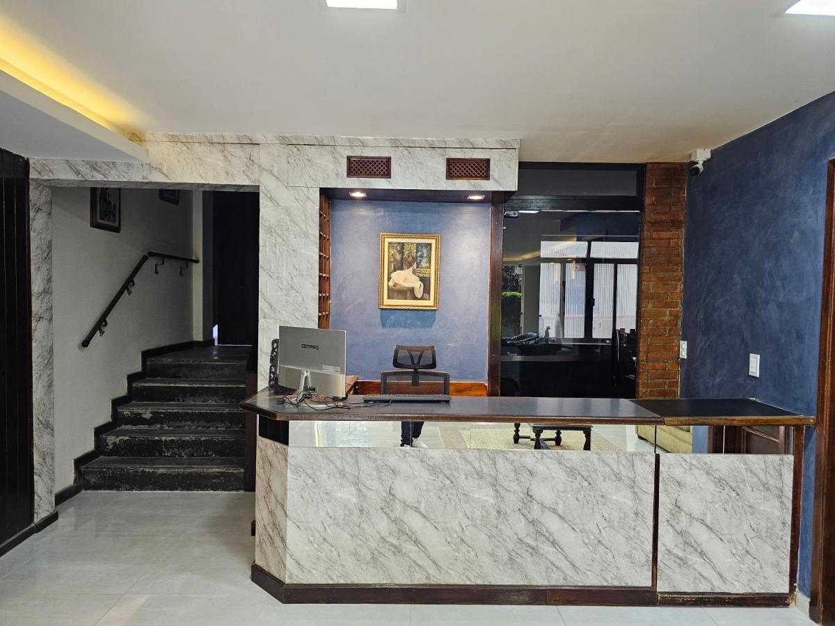 Recepção e salão de estar do Hotel Princesinha do Café, com quadros clássicos e sofás de couro — foto 5